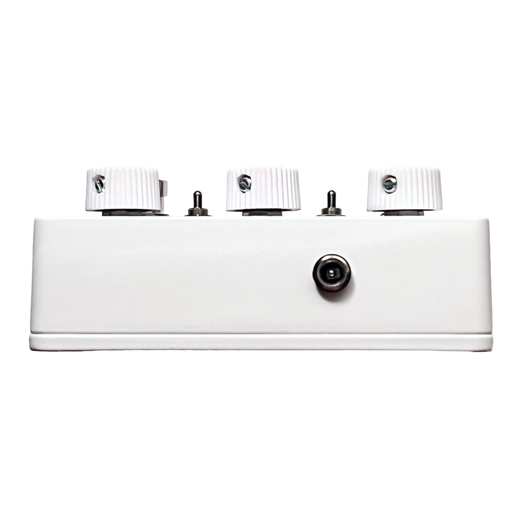 White guitar effects pedal with three knobs and a socket on a white background